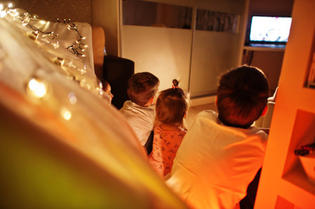 Kids in tent waching tv at night home. Hygge mood.の写真素材