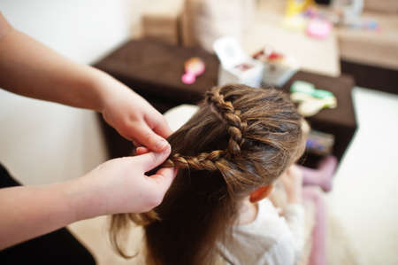 Mother and daughter weekend together at home, mom making hairstyle.の写真素材