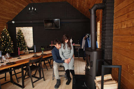 Couple in modern wooden house spending time together near fireplace in warm and love.の写真素材