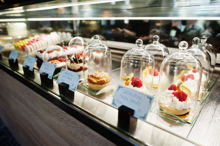 Tartlet desserts under the glass dome in shop window at cafe.の写真素材