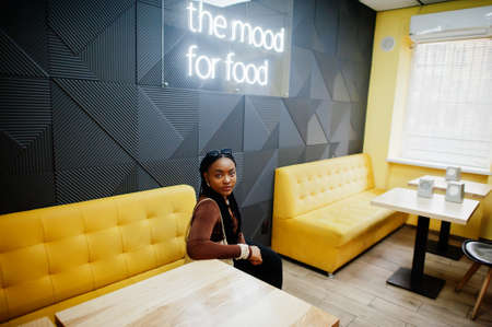 In the mood for food. African woman in cafe.の写真素材