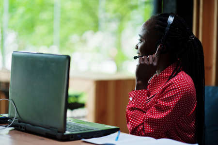 African american woman works in a call center operator and customer service agent wearing microphone...