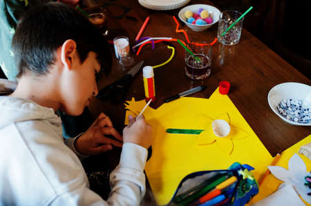 Preparing to Easter concept. Kids making by hands bunny and eggs.