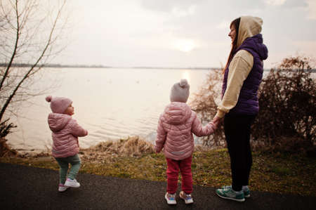 Mother with daughters walking on the path by the lake.の写真素材