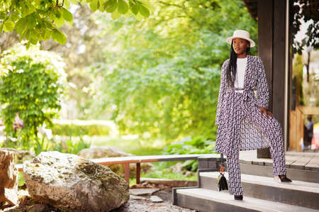 Beautiful african american woman natural makeup wear fashion clothes casual black and white dress code office style total blouse and pants suit and hat.の写真素材