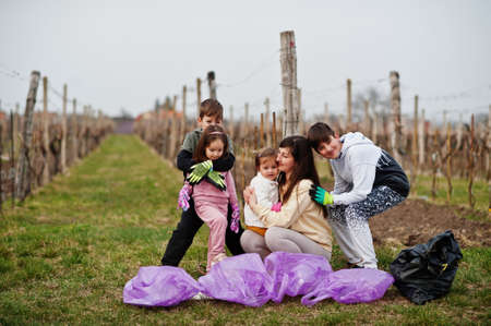 Family with trash bag garbage collecting while cleaning in the vineyards . Environmental conservation and ecology, recycling.の写真素材