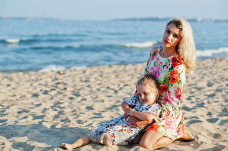 Mother and beautiful daughter having fun on the beach. Portrait of happy woman with cute little girl on vacation.の写真素材