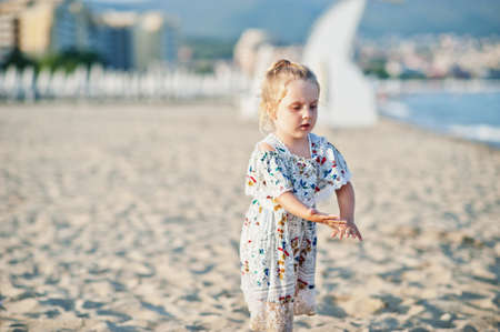 Daughter having fun on the beach. Portrait of happy cute little baby girl on vacation.の写真素材