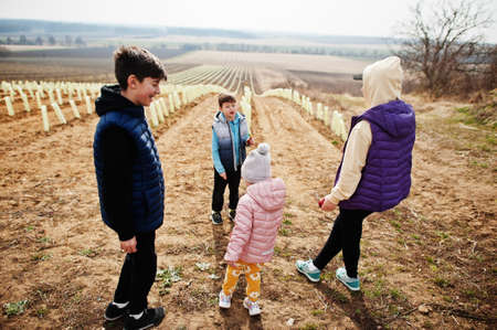 Mother with kids stand against vineyard in early spring.の写真素材