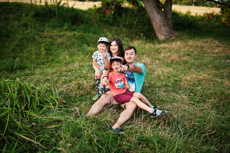 Happy young family: mother, father, two children son on nature having fun.