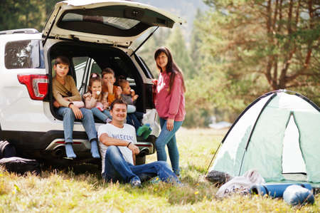 Large family of four kids. children in trunk. Traveling by car in the mountains, atmosphere concept. american spirit.の写真素材