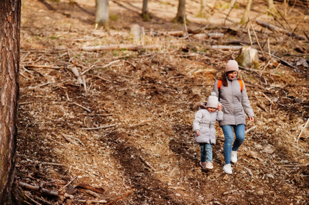Mother with daughter wear jacket and hat in early spring forest.の写真素材