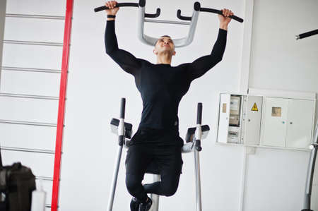 Muscular arab man training in modern gym.