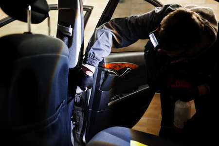 Man in uniform and respirator, worker of car wash center, cleaning car interior cleaning brush . Car...