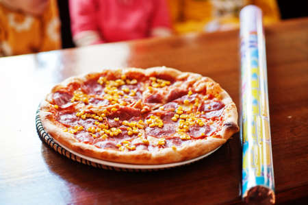 Pizza with corn and meat in wooden table.の写真素材