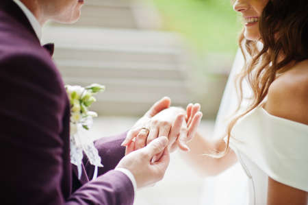 Bride and groom holding hands, close up. Their happy wedding day.