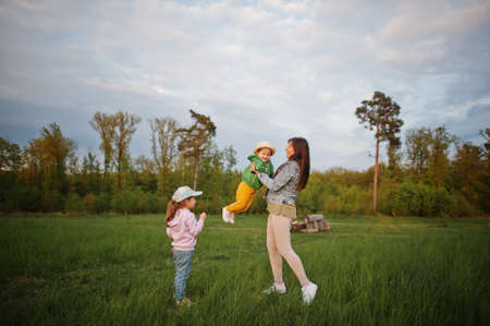 Mother with kids having fun together at meadow.の写真素材