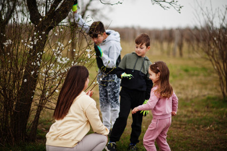 Mother with kids working in spring garden.