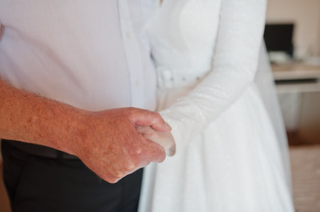 Father hold his daughter bride hand at her wedding day.の写真素材