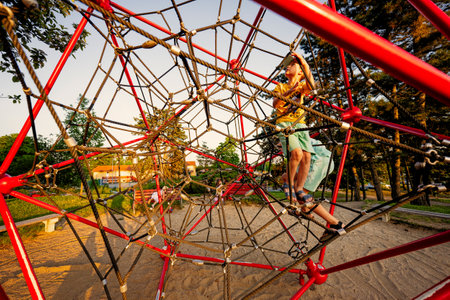 Kids play in rope polyhedron climb at playground outdoor.の写真素材