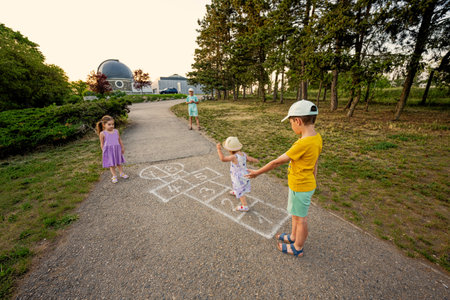 Kids playing hopscotch in park. Children outdoor activities.の写真素材