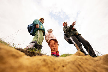 Three kids explore limestone stone cave at mountain.の写真素材