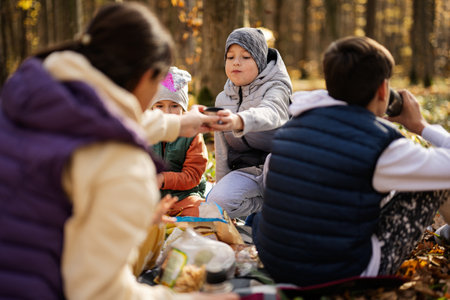 Mother with kids in family picnic at autumn forest.の写真素材
