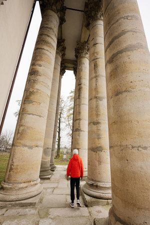Boy against columns of baroque roman cattholic church in Pidhirtsi, Lviv Oblast, Ukraine.の写真素材