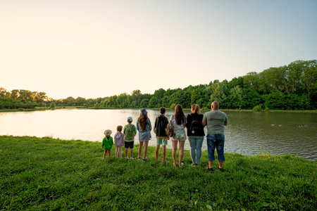 Big and large family against lake in sunrise. Six children. Parents and kids.の写真素材