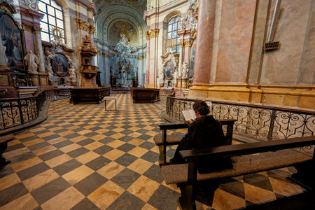 Rajhrad, Czech Republic - May 22, 2022: Benedictine monk sit in church of St. Peter and Paul and read Holy Bible in Rajhrad, Czech Republic.のeditorial素材