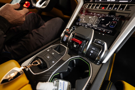 Ternopil, Ukraine- November 11, 2022:  Key in gearbox of yellow Lamborghini Urus with driver.