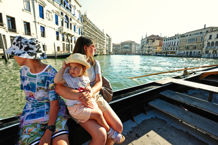 Mother with kids sit at gondola in Venice,  Italy.の写真素材