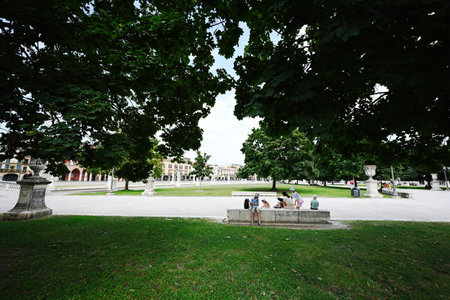 Family rest in park with canal on square Prato della Valle and Basilica Santa Giustina in Padova, Veneto, Italy.の写真素材