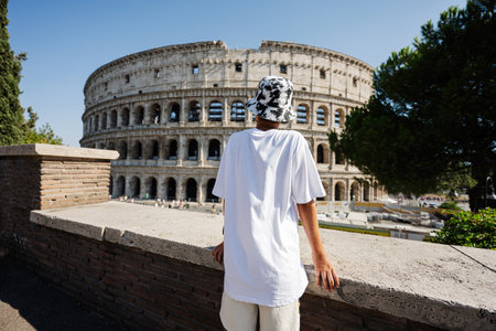 Back of boy tourist enjoy view Colosseum in the old city center of Rome, Italy.