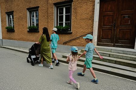 Mother with baby carriage and children walking in Hallstatt, Austria.の写真素材