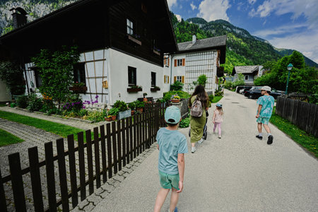 Back of mother with baby carriage and children walking in Hallstatt, Salzkammergut, Austria.の写真素材