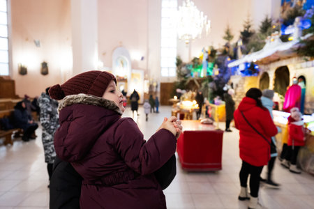 Mother with daughter looking at Christmas nativity crib scene in church.の写真素材