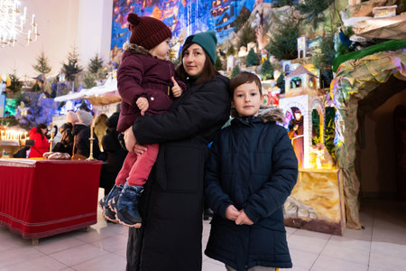 Mother with children visit Christmas nativity crib scene in church.の写真素材