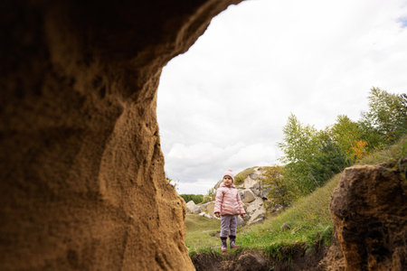 Baby girl explore limestone stone cave at mountain.の写真素材