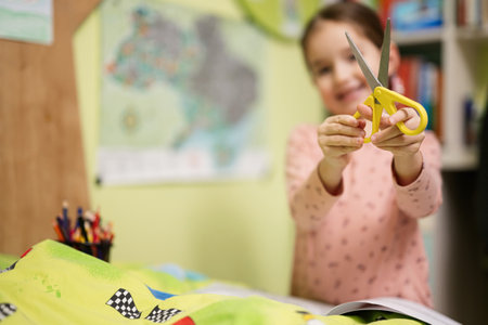 Young girl show scissors in her room.の写真素材