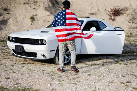 Back of man with USA flag near his white american muscle car in career.の写真素材