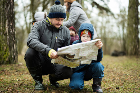 Father with son looking at map in the forest.の写真素材