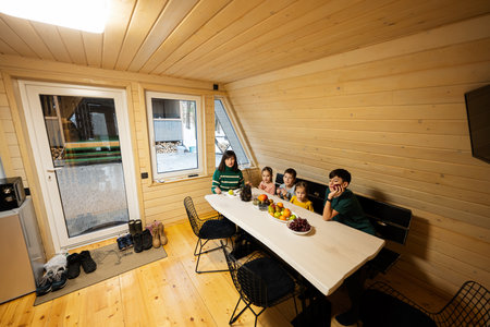 Mother with four children eat fruits in wooden country house on weekend.の写真素材