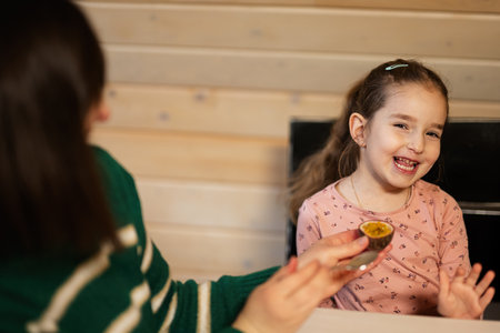 Mother with daughter eat fruits, she gave a passion fruit.の写真素材