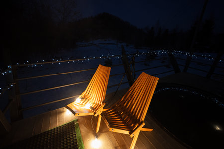 Two chairs in wooden terrace of the cottage. Scandinavian night.の写真素材