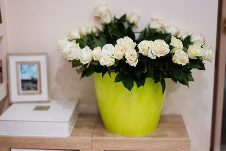 White roses flowers bouquet in green pot at home.の写真素材