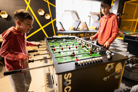 Brothers playing table football in kids play center.の写真素材