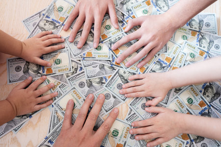 Kids hands on dollar money. Distribution of family property.