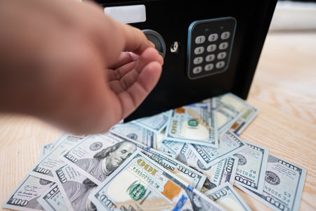Male open with keys lock safe door against dollar money.の写真素材