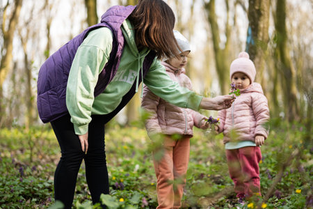 Mother with two daughters on forest. Outdoor spring leisure concept.
